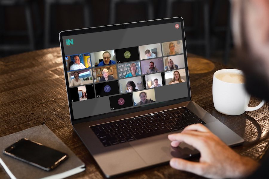 Business man enjoys NetworkIN referral marketing meeting on his Macbook computer with a coffee