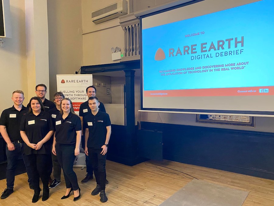 Rare Earth Team in front of a presentation screen