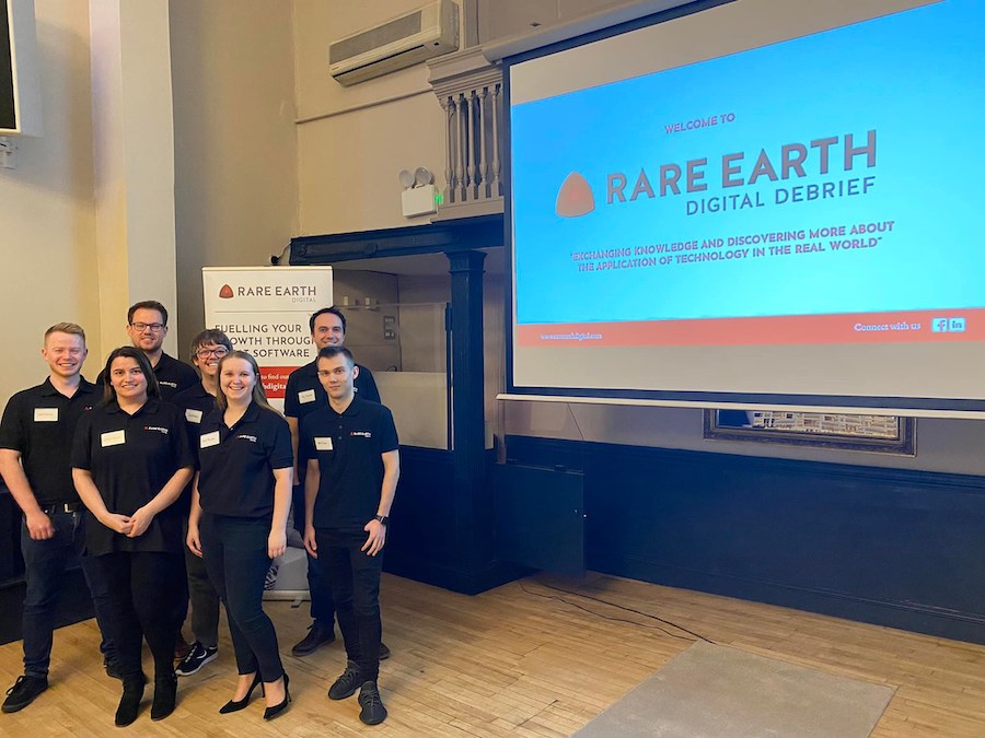 Rare Earth Team in front of a presentation screen